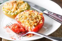 a white plate topped with two stuffed tomatoes