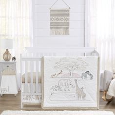 a baby crib bedding set with an elephant and giraffe design on it