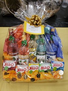 a basket filled with assorted liquor bottles and candy wrapped in cellophane wrap