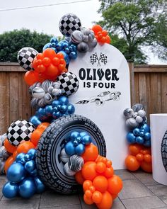 an assortment of balloons in the shape of cars and checkered tires are on display