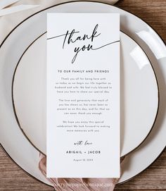 a white plate topped with a thank you card on top of a wooden place setting