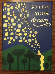 a painting that says go live your dream on the side of a wooden table with trees