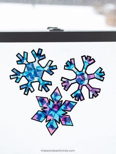 the snowflakes are cut out of paper and placed on a white board