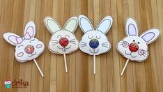 three bunny lollipops are sitting on a wooden table next to each other