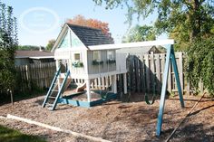 a wooden swing set in the middle of a yard