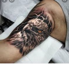 an eagle tattoo on the arm with lightning coming out of its eyes and behind his head