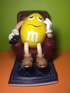 a yellow m is sitting in a chair