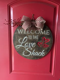 a red door with a welcome sign hanging on it's side and the words, welcome to the love shack