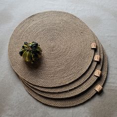 four placemats on top of each other with a small plant in the middle