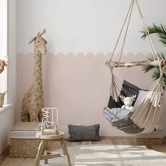 a baby's room with a hammock and stuffed giraffes