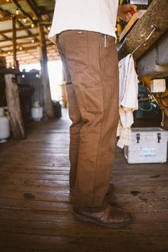 Strong, durable, and ready to roam. Made to be your everyday workhorse, the Bison Pant grazes with ease. Offered in a heavy weight rigid canvas, relaxed fit silhouette, & sturdy herringbone pocketing, this style gets better with time. Details include strongly made top entry seam belt loops, front pocket reinforced inset (that doubles as a knife clip), rear utility pockets for accoutrements, signature side sunglass loop, and hard wearing triple-needle at side seams & center back seam. Fit: Model Rugged Straight Leg Pants For Fall, Rugged Fall Pants With Pockets, Rugged Straight Leg Bottoms For Fall, Brown Workwear Jeans With Side Pockets, Brown Jeans With Side Pockets For Work, Rugged Bottoms With Pockets For Fall, Brown Cotton Cargo Pants With Welt Pockets, Utility Cargo Pants With Welt Pockets For Outdoor, Rugged Brown Pants With Pockets