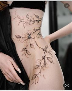 a woman's stomach with flowers on it and leaves drawn on the side of her body