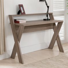 a wooden desk with a lamp and pictures on the wall