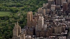 an aerial view of new york city with many buildings and trees in the foreground