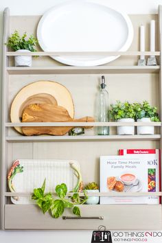 a kitchen shelf filled with plates and plants