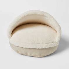 a white dog bed with a round cushion on the top and bottom, in front of a