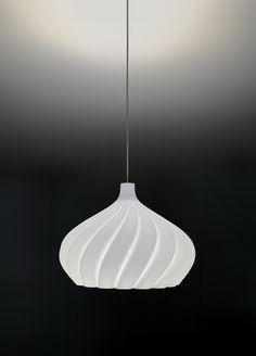 a white light hanging from a ceiling in a room with black walls and flooring