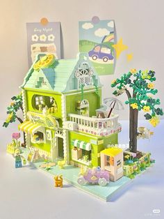 a green toy house with cars and trees