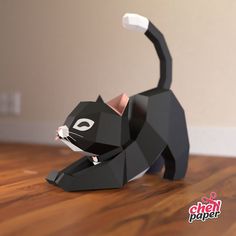 a black paper cat sitting on top of a wooden floor