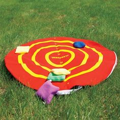 a red and yellow frisbee laying in the grass