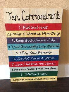 a wooden sign with ten commandments written on it in different colors and sizes, along with the words ten commandments