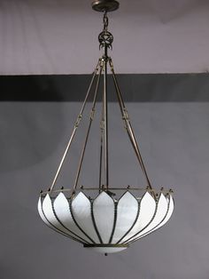 a chandelier hanging from the ceiling in a room with gray walls and flooring