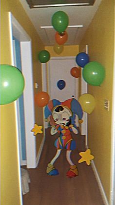 the clown is walking down the hallway with balloons