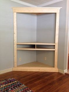 an empty room with some shelves on the wall and a rug in front of it