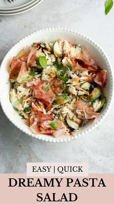 a white bowl filled with salad next to two plates on top of a table and the words easy quick dreamy pasta