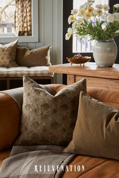 a living room filled with lots of furniture and flowers in a vase on top of a table