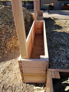 two wooden planters sitting in the dirt