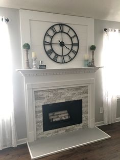 a clock mounted on the wall above a fireplace