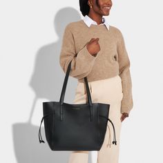 Check out our new-in Ashley Tote Bag - a true must-have in every trendsetter's wardrobe. Designed to complement and enhance your daily routine, with a spacious interior that is laptop and iPad friendly, it's perfect for work, travel or leisure. The internal slip pocket provides added convenience, allowing you to keep your essentials organized and secure. The vegan leather material and gold-tone hardware add a touch of sophistication to your look, while the handle threading detail is completely u Vegan Leather Tote Bag, Personalized Gift Bags, Vegan Leather Tote, Comfortable Tops, Work Travel, Chic Boutique, Black Tote Bag, Threading, Tote Backpack