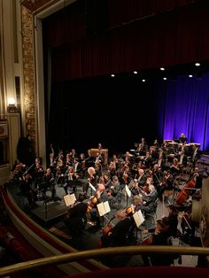 an orchestra performing in front of a stage