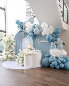 a blue and white dessert table with balloons