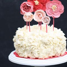 a cake with white frosting and pink flowers on top