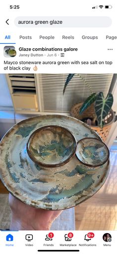 someone is holding an old plate with two bowls on it