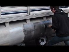 a man in black jacket next to large metal object