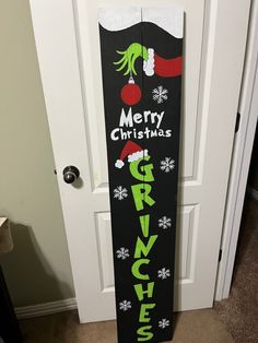 a black and green christmas sign sitting on top of a door