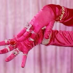 a woman's hands in pink and gold with jewels on them