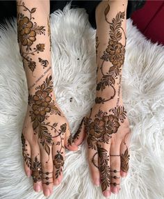 two hands with henna tattoos on them