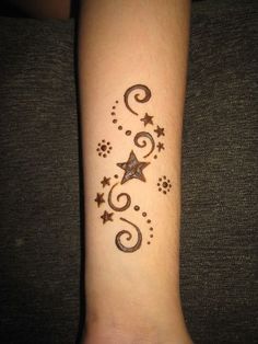 an image of a tattoo design on someone's arm with stars and swirls