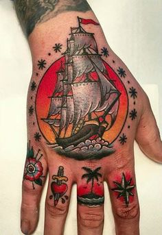 a person's hand with tattoos on it and a ship in the middle of the palm tree