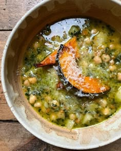 a bowl filled with soup on top of a wooden table