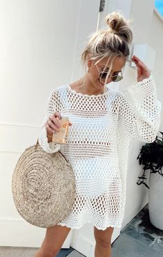 a woman in white dress holding a straw bag