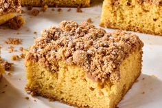 several pieces of cake sitting on top of a white paper covered tablecloth with crumbs all over it