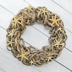 a wreath made out of jute and starfishs on a white wooden background