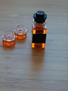 three jars with honey sitting on top of a wooden table next to two empty ones