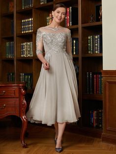 a woman standing in front of a bookshelf wearing a dress with sequins on it