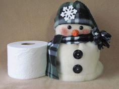 a snowman is next to two rolls of toilet paper